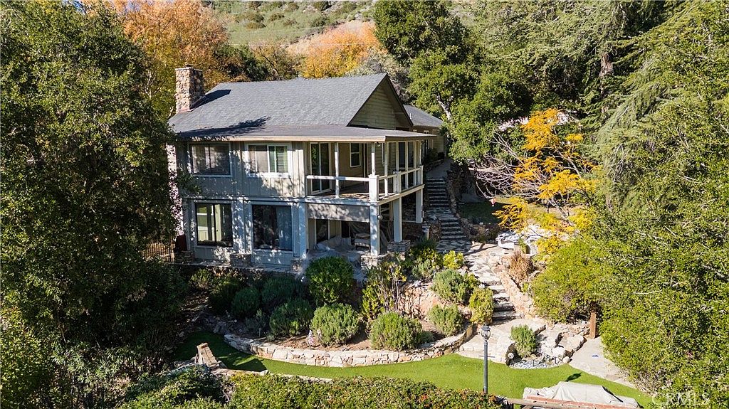 Aerial view of 2305 Sugarloaf Dr, a lakeside estate above Malibou Lake surrounded by mature trees
